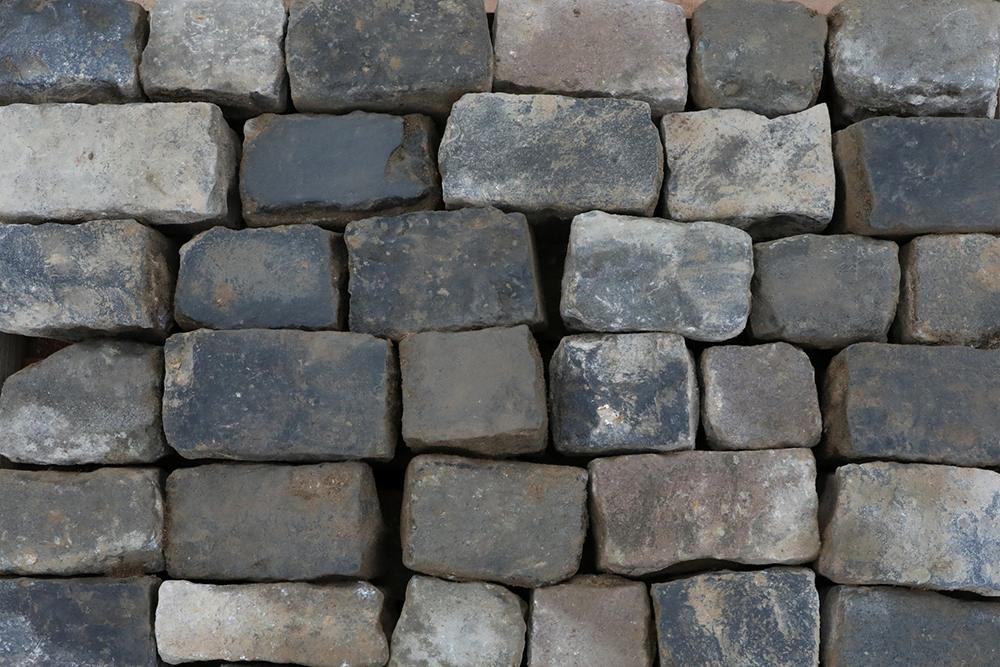 A spread of dry reclaimed blue grey granite cobbles with worn faces and authentic weathering and patina