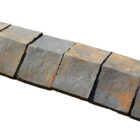 A run of weathered blue saddleback wall copings showing iron staining and minor chips