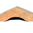 Profile of a run of weathered blue saddleback wall copings showing iron staining and minor chips