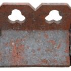 A detail of a short run of reclaimed double club, or trefoil, crested ridge tiles with a weathered patina of lichen and age related discolouration.