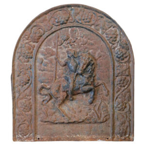 An antique and weathered cast iron fireback showing a regal horse mounted figure within an arch of grape and vine motif.