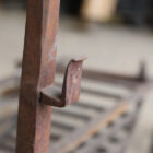 Detail of a reclaimed wrought iron Inglenook fire basket and fire dogs with authentic surface patina