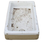 A large reclaimed butler sink with white ceramic rim and basin with buff fireclay base and drainage hole placed centrally at one end.