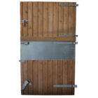 A reclaimed softwood stable door with galvanised fittings and stainless steel kick/bite plate