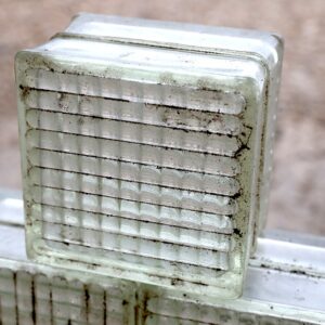 A weathered but iconic reclaimed textured glass brick from the mid 1900's