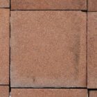 A close up of a tile from a wide spread of reclaimed 4 inch Heather Brown quarry tiles from the Dennis Ruabon Hafodex range, showing minor variation in colour and an aged patina of minimal edge wear and remnants of mortar.