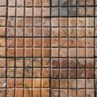A small area of laid reclaimed and very rare Victorian salt glazed stable pavers, showing the unusual 10 bar design and rich colour of orange, russet and brown hues of the salt glaze firing process.