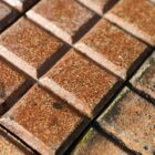 A close up of the fabulous finish on these reclaimed and very rare Victorian salt glazed stable pavers, showing the unusual 10 bar design and rich colour of orange, russet and brown hues of the salt glaze firing process.