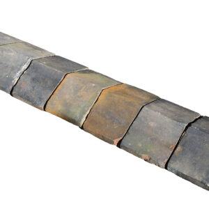 A run of reclaimed Staffordshire blue, square edge saddleback wall coping, with a weathered patina of discolouration and small chips and marks