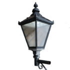 A weathered Victorian style garden lantern with patina of peeling black paint