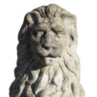 Detail of a reclaimed composite stone statue of a lion holding a shield with a weathered patina and classic pose