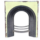A reclaimed cast iron fireplace insert with yellow painted face and decorative arch