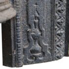 Detail of a reclaimed cast iron fireplace insert with yellow painted face and decorative arch